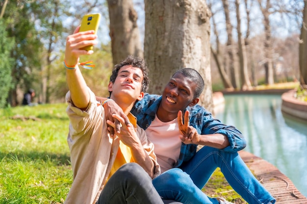 Selfie of a multiethnic gay male couple talking quietly in the park lgbt concept