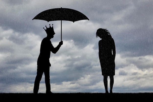 Selfishness and sexism Selfish man with a crown holding an umbrella laughs at an upset woman in the rain