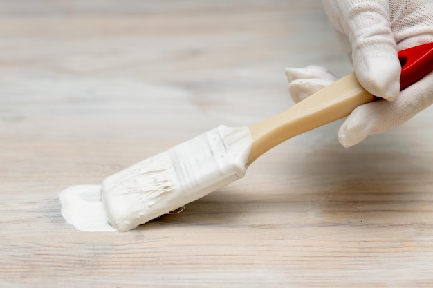 Selfrepair of furniture and painting Women's hand with a brush