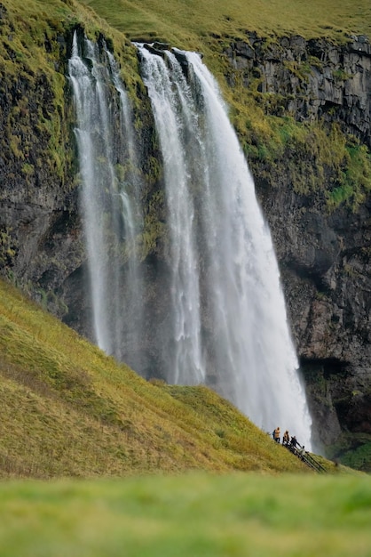 Seljalandfoss waterfall in iceland long shot with tourists