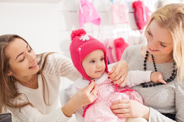 The seller shows girl winter pink hat with pompom to select purchases