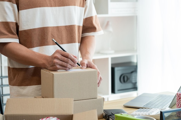 the seller writing his customer's address on the parcel and being ready for sending it