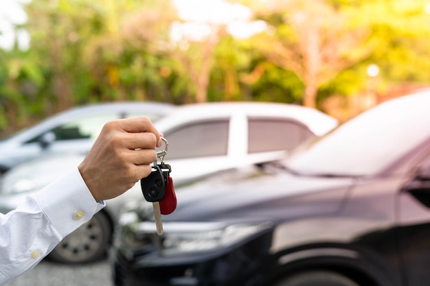 Selling car car sale deal concept The dealer gives the car keys to the new owner or renter with an insurance contract