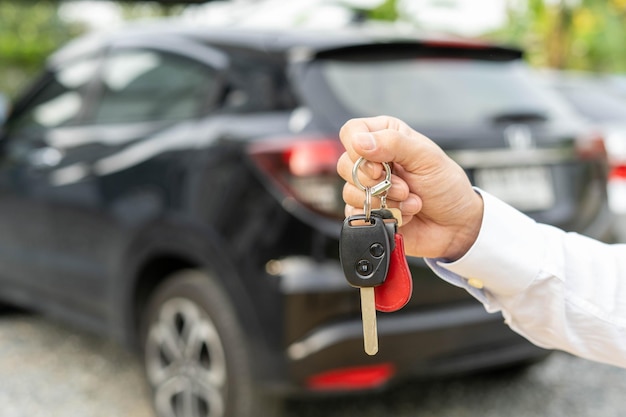 Selling car car sale deal concept The dealer gives the car keys to the new owner or renter with an insurance contract