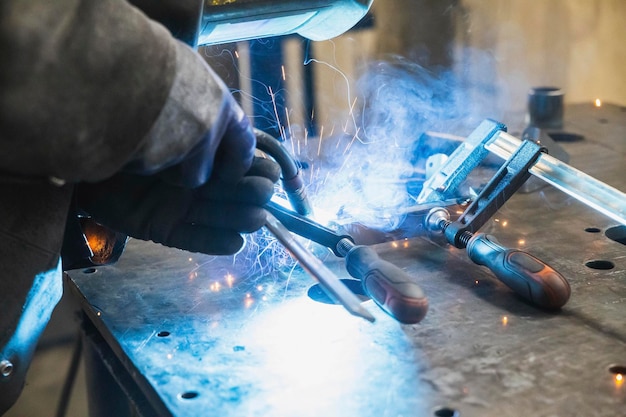 Photo semi-automatic welding with sparks and smoke at the factory