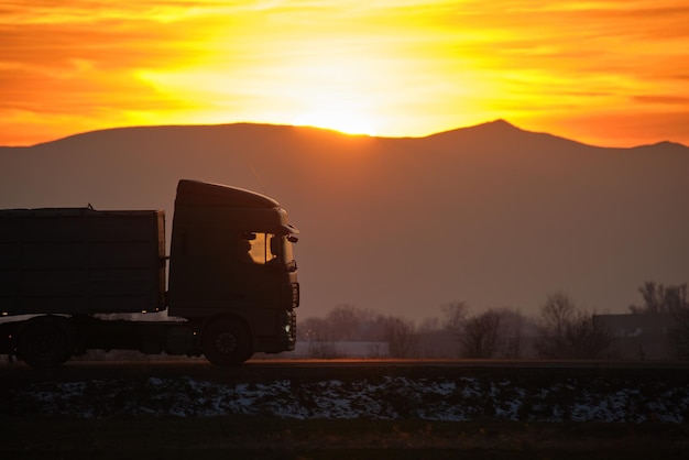 Semitruck with cargo trailer driving on highway hauling goods in evening Delivery transportation and logistics concept