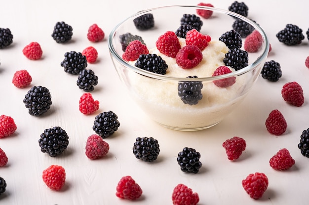 Semolina pudding porridge dessert with blackberry and raspberry in glass bowl