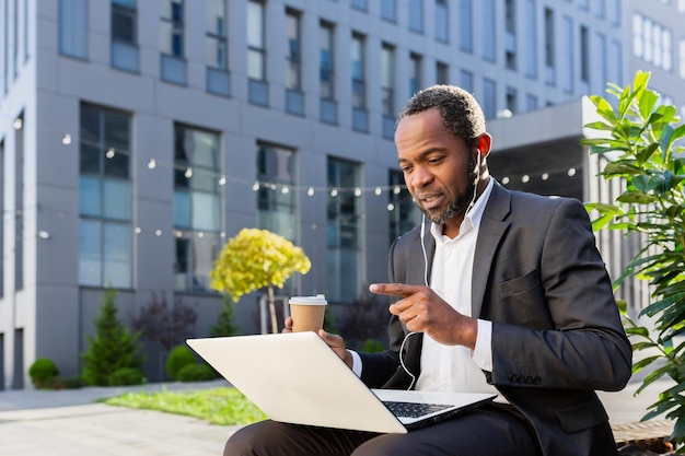 A senior african american male businessman is talking to his team via video call sitting near the