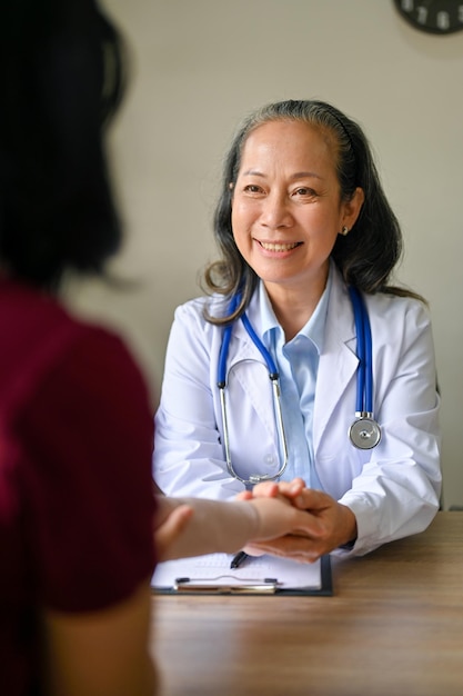 A senior Asian female orthopedic doctor following up a medical case of her patient