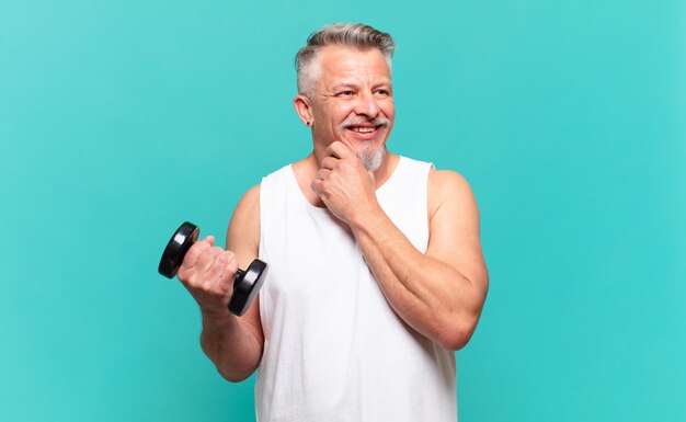 Senior athlete man smiling with a happy, confident expression with hand on chin, wondering and looking to the side