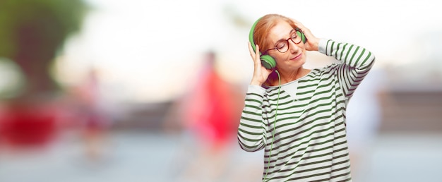 Senior beautiful woman listening music with a headphones