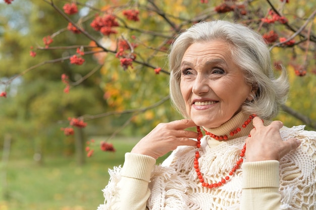 Senior beautiful   woman  with lace from berries posing outdoors