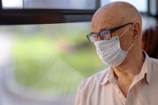 Senior bus passenger taking care of health and wearing mask