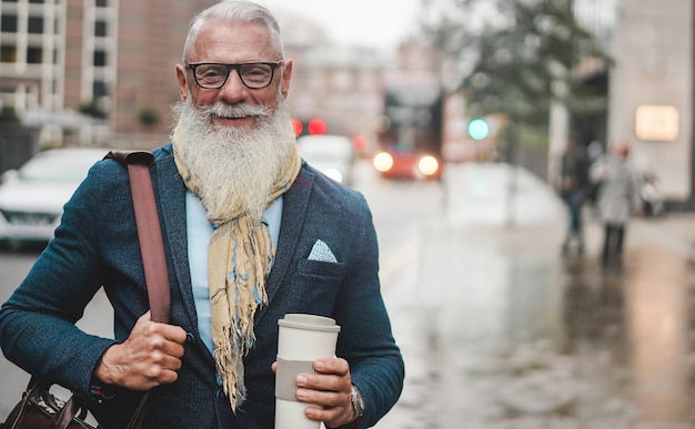 Senior business man going to work - Hipster entrepreneur drinking coffee while waiting bus - Job, leadership, fashion and confident concept - Focus on face