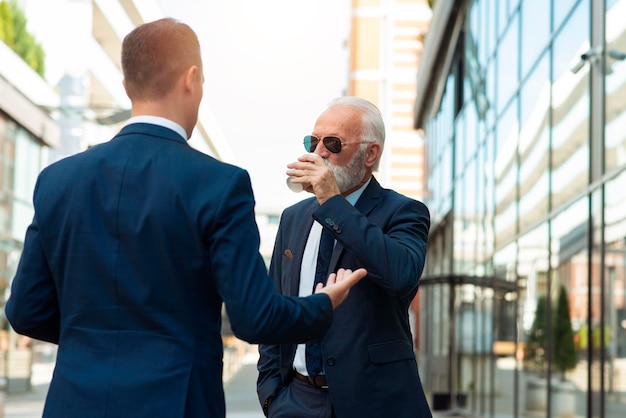 Senior businessman discussing something positive with his young colleague