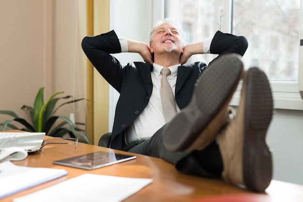 Senior businessman relaxing in his office