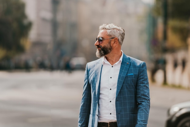 A senior businessman in a suit walking around the city after work