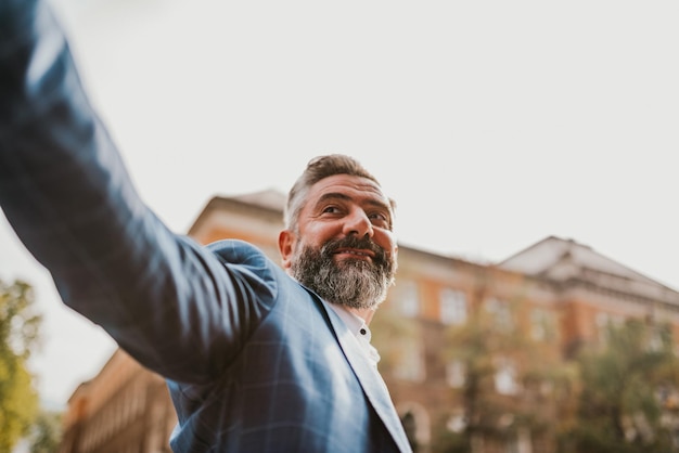 A senior businessman in a suit walking around the city after work