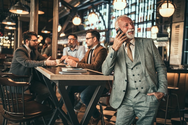 Senior businessman talking on the phone in the pub