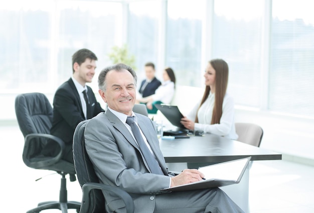 Senior businessman with a clipboard on the background of the office