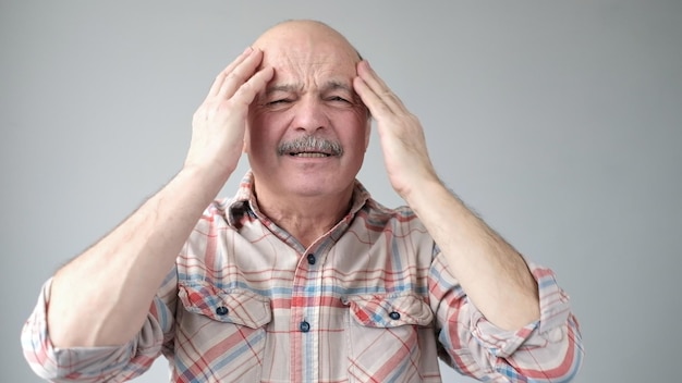 Senior caucasian man showing how much his head hurts experiencing pain