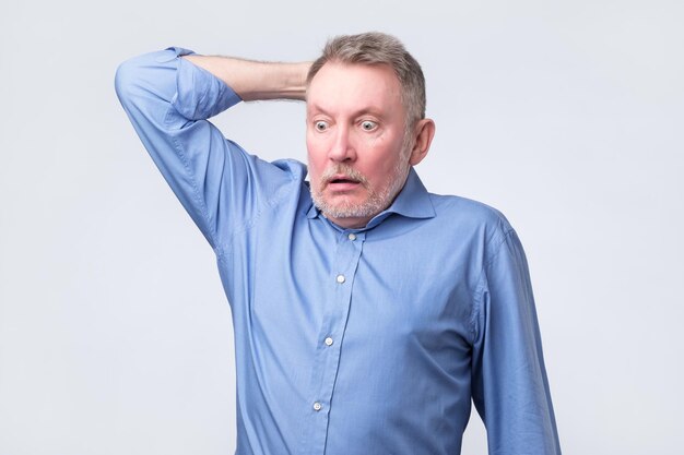 Senior caucasian man surprised with hand on head