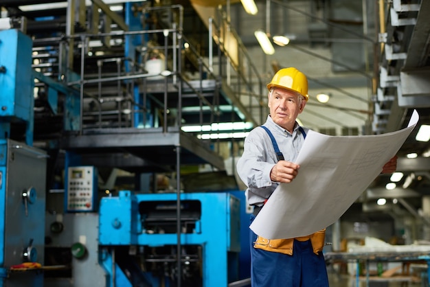 Senior Construction Worker Holding Floor Plans