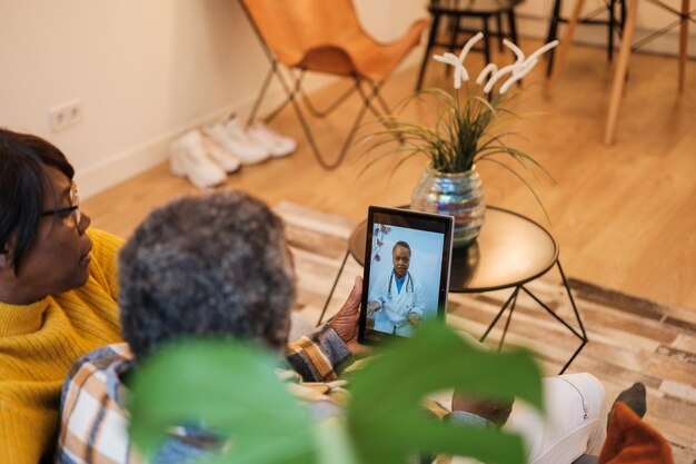 Senior couple attended by the doctor through the tablet through telehealth care Concept healthcare medicine doctor