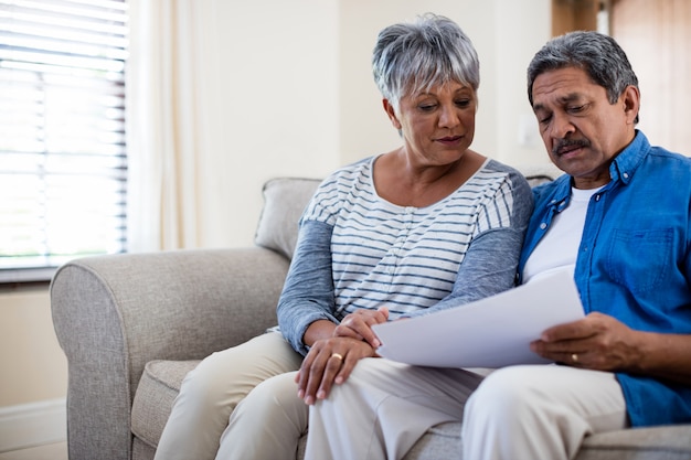 Senior couple checking bills in living room