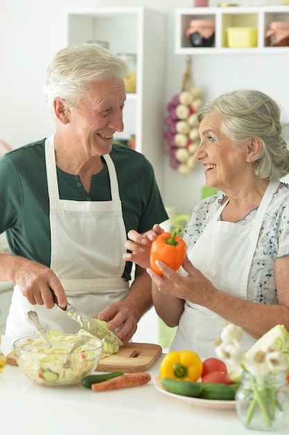 Senior couple cooking together at kitchen