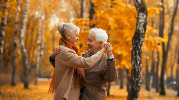 A senior couple dances in the park on a crisp autumn day surrounded by yellow foliage