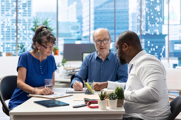 Senior couple discussing with a financial advisor to choose retirement plans