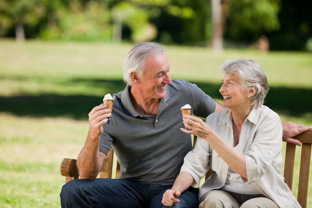 Senior couple eating an ice cream on a bench