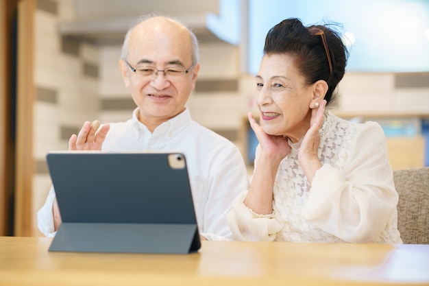 Senior couple enjoying online communication with tablet PC