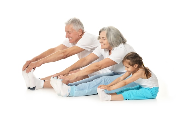 Senior couple exercising with granddaughter isolated on white background