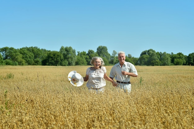 Senior couple having fun at summer field during vacation