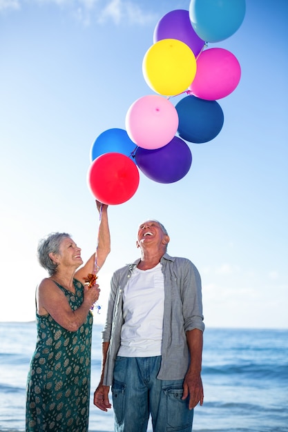 Senior couple holding balloons