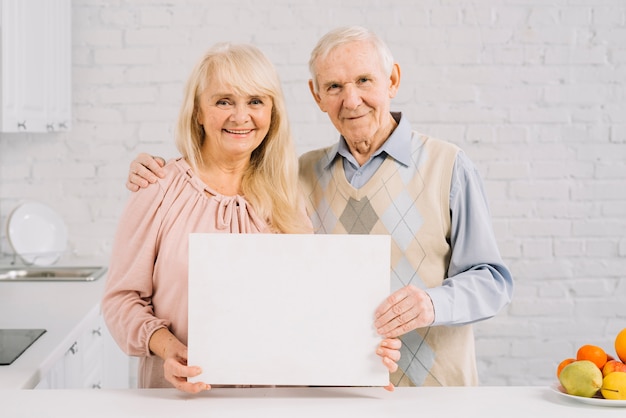 Senior couple holding template in kitchen