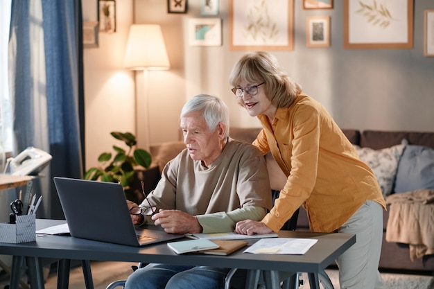 Senior couple learning to use laptop