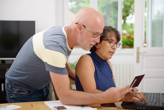 senior couple prepare the holidays on the internet