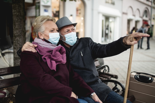 Senior couple in protective mask outdoors in the city. Air pollution concept.