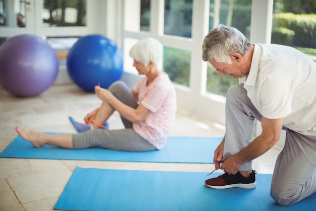 Senior couple removing their shoes at home