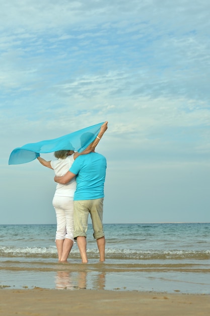 Senior couple sitting on a rock looking a sea