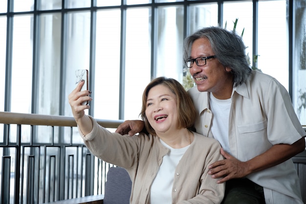 Senior couple taking pictures of selfies, look happiness and warm on vacation.