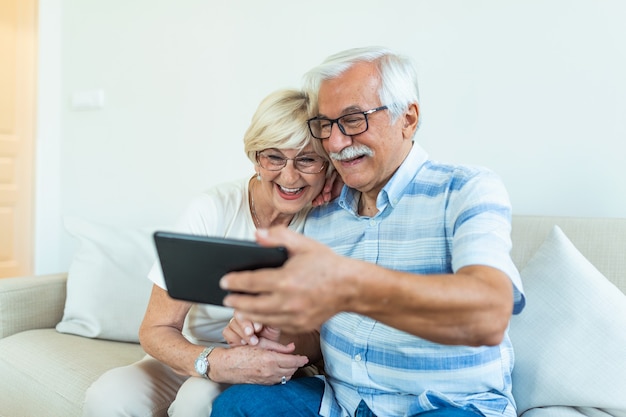 Senior couple using digital tablet at home