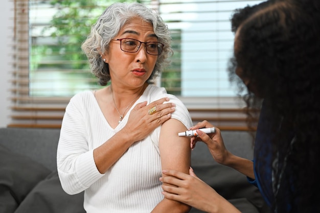 Senior female diabetes taking insulin from nurse Diabetes and elderly healthcare concept