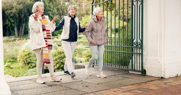 Photo senior friends walking and talking together on an outdoor path to relax in nature with elderly women in retirement people happy conversation and healthy exercise in the park in autumn or winter