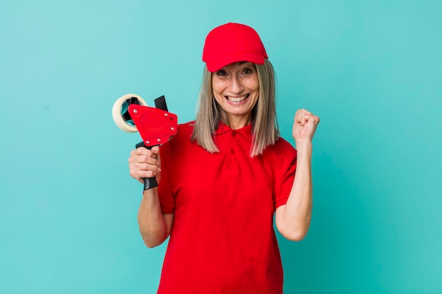 Senior gray hair woman feeling shockedlaughing and celebrating success packer employee concept