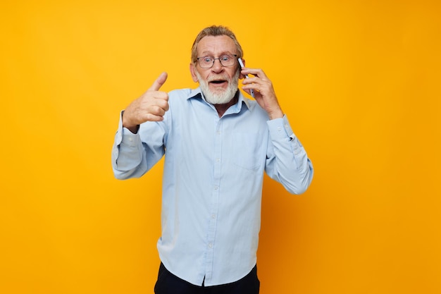 Senior greyhaired man talking on the phone posing closeup cropped view