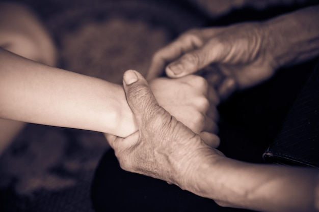 senior hand hold young woman with love